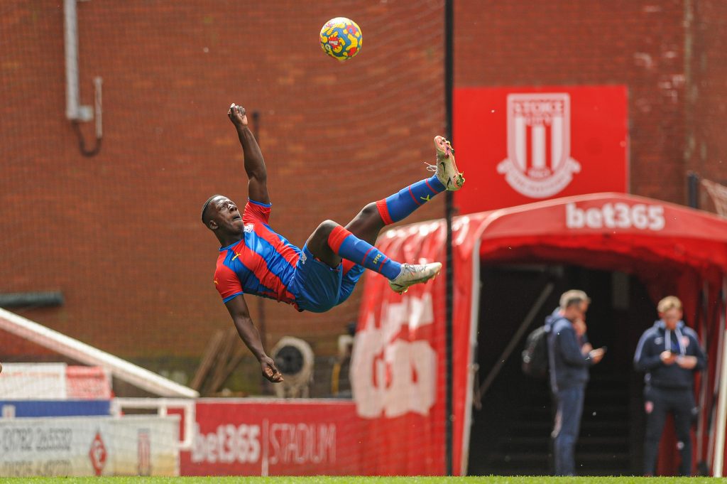 A player about to take a kick in mid-air on the Stoke City FC pitch with the tunnel in the background