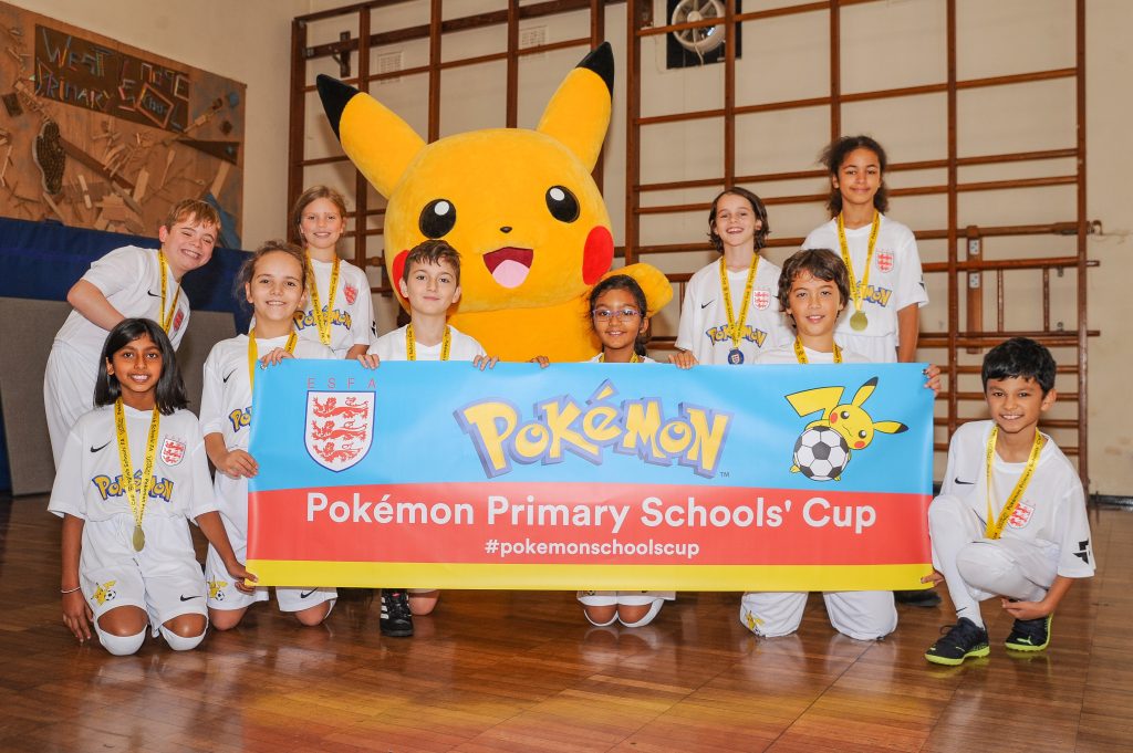 Primary School children holding a Pokémon Schools' Cup Banner with Pikachu 