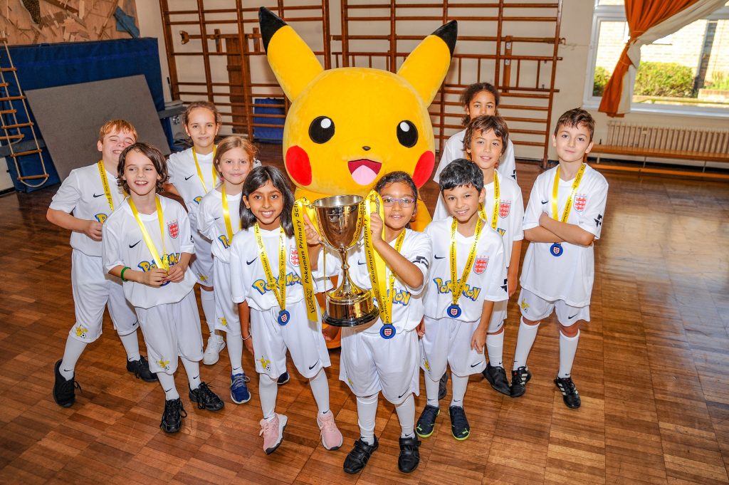 Primary School Children holding the Pokémon Schools' Cup trophy with Pikachu 